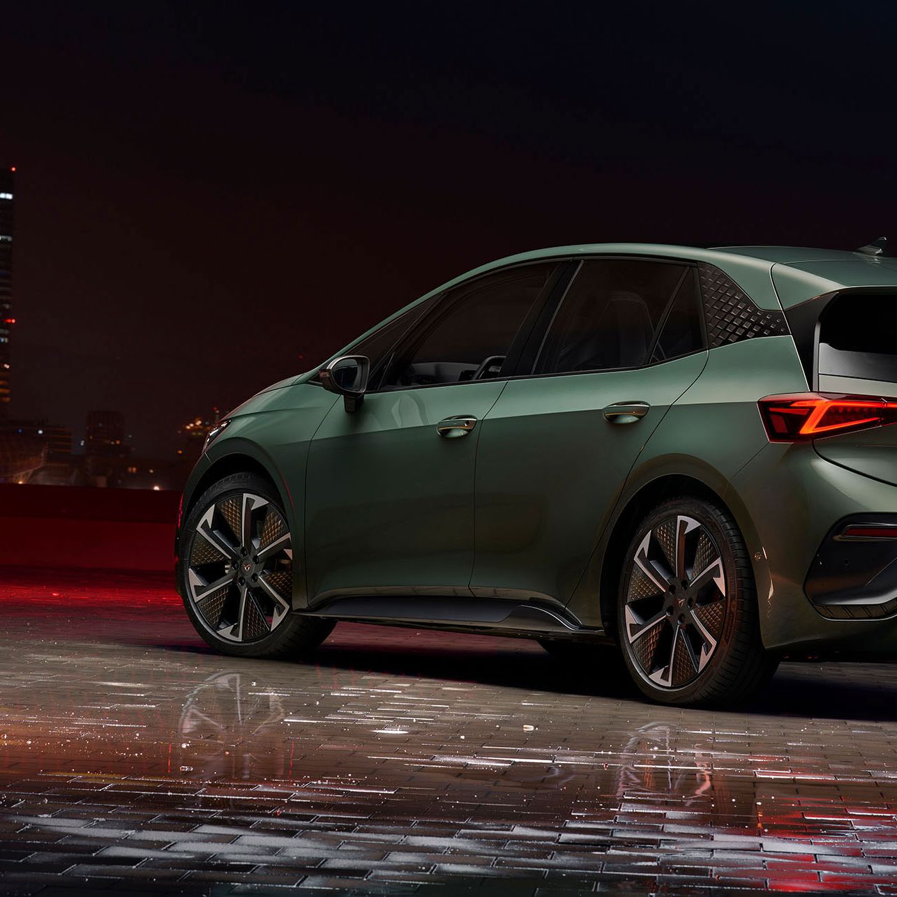 Seitliche Heckansicht eines grünen CUPRA Born VZ bei Nacht.