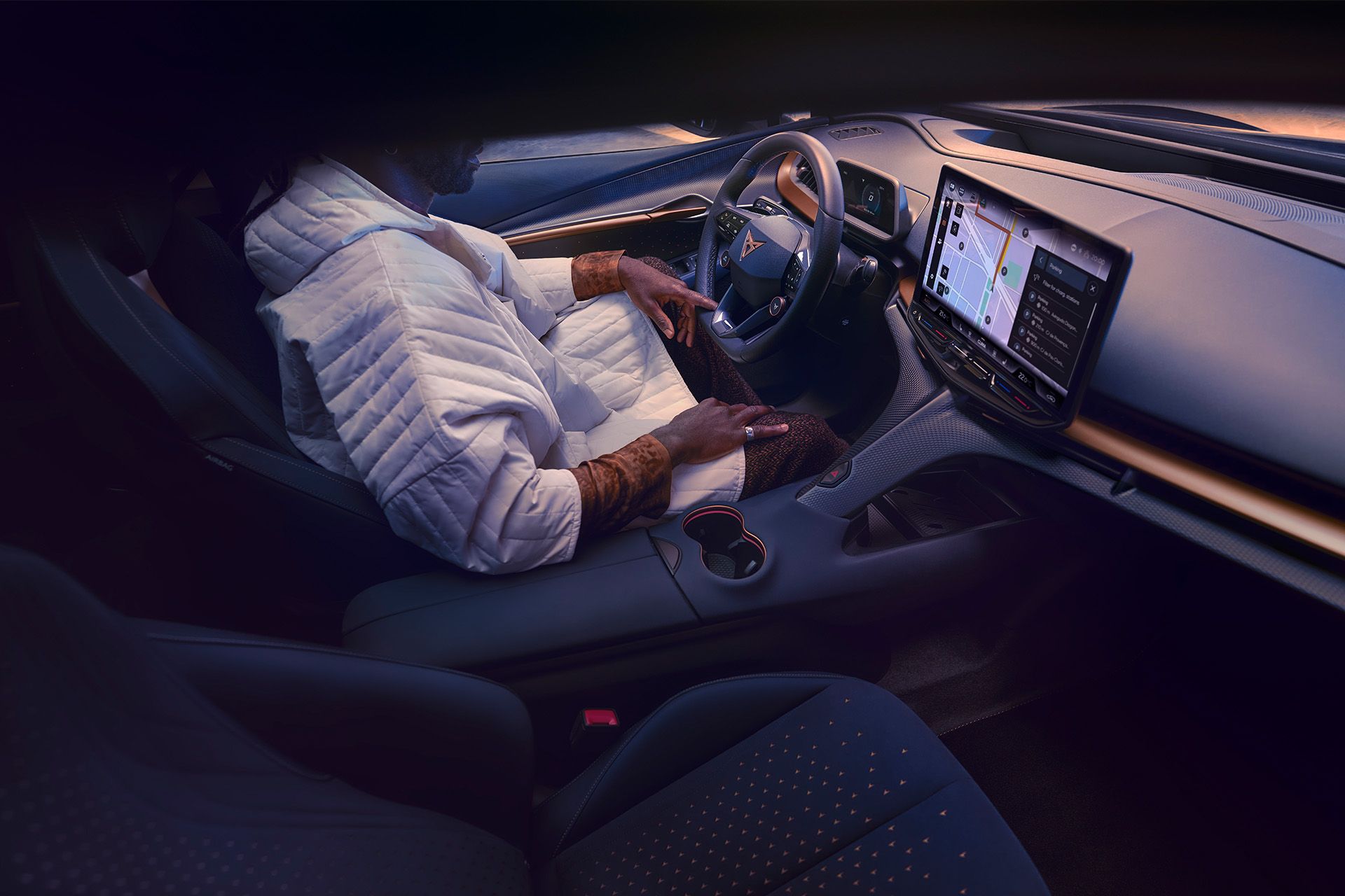 Ein Mann sitzt am Fahrersitz eines CUPRA Tavascan.