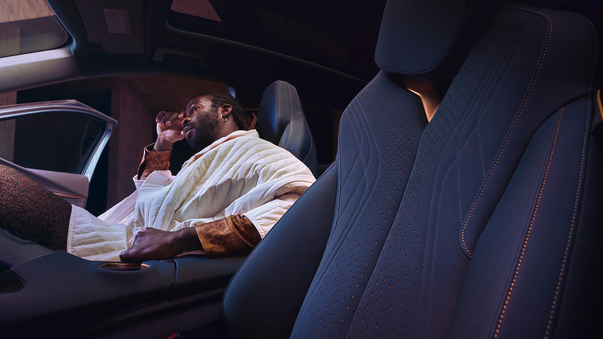 Innenansicht eines CUPRA Tavascan, ein Mann sitzt auf dem Beifahrersitz.