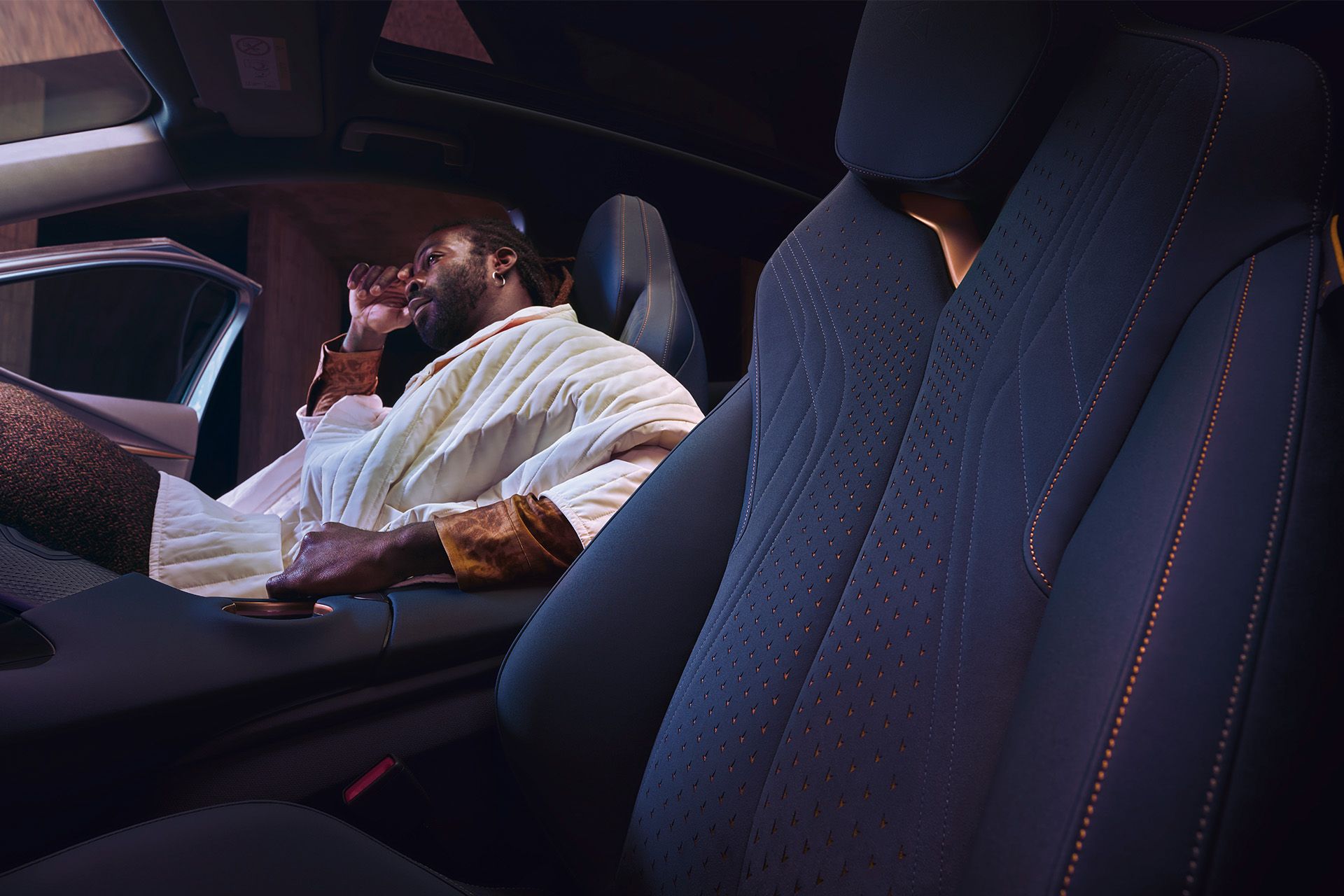 Innenansicht eines CUPRA Tavascan, ein Mann sitzt auf dem Beifahrersitz.