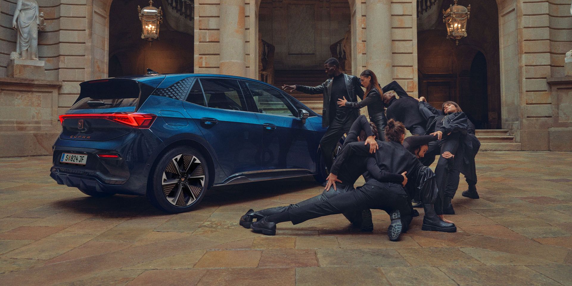 Eine Gruppe von Personen befindet sich neben einem blauen CUPRA Born.