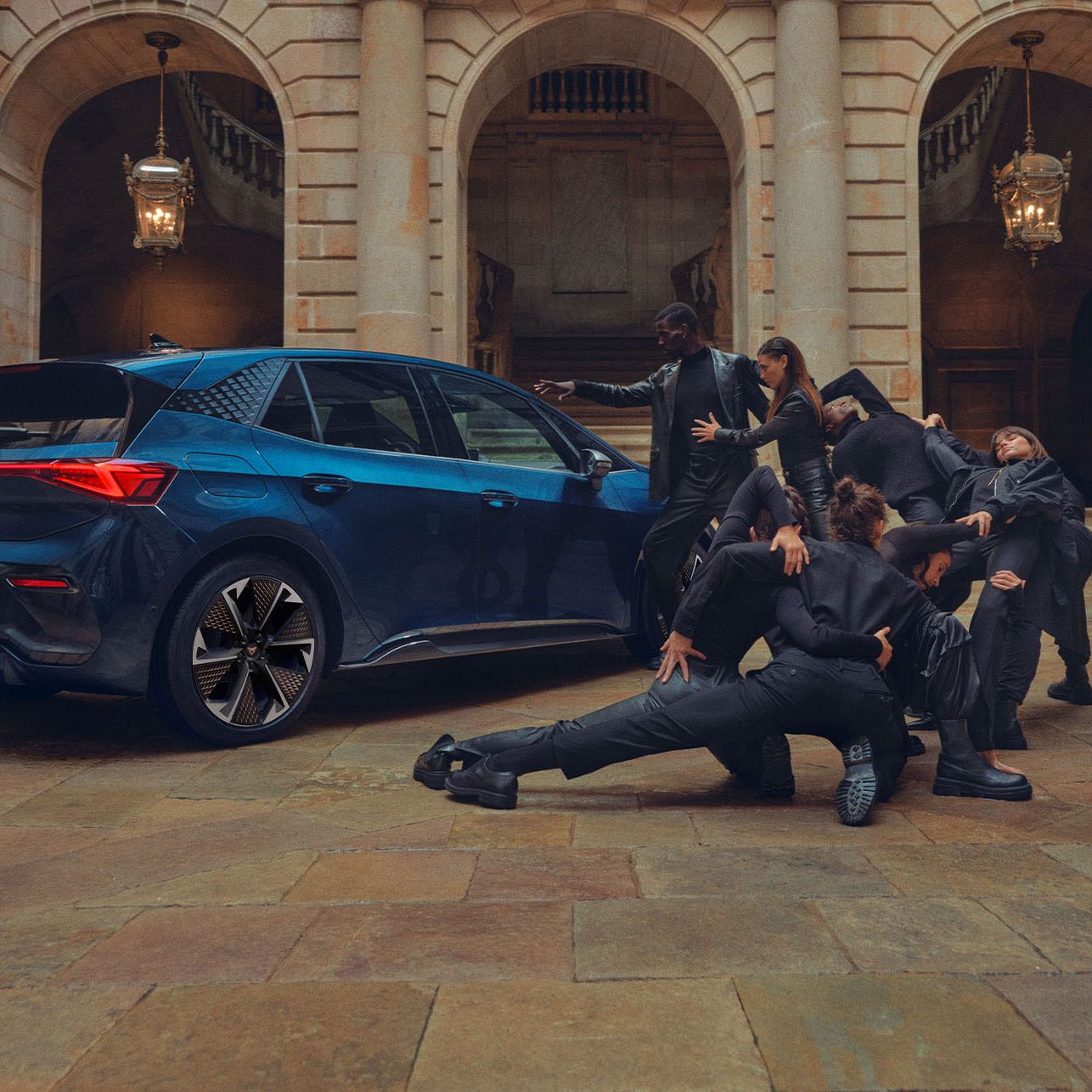 Eine Gruppe von Personen befindet sich neben einem blauen CUPRA Born.