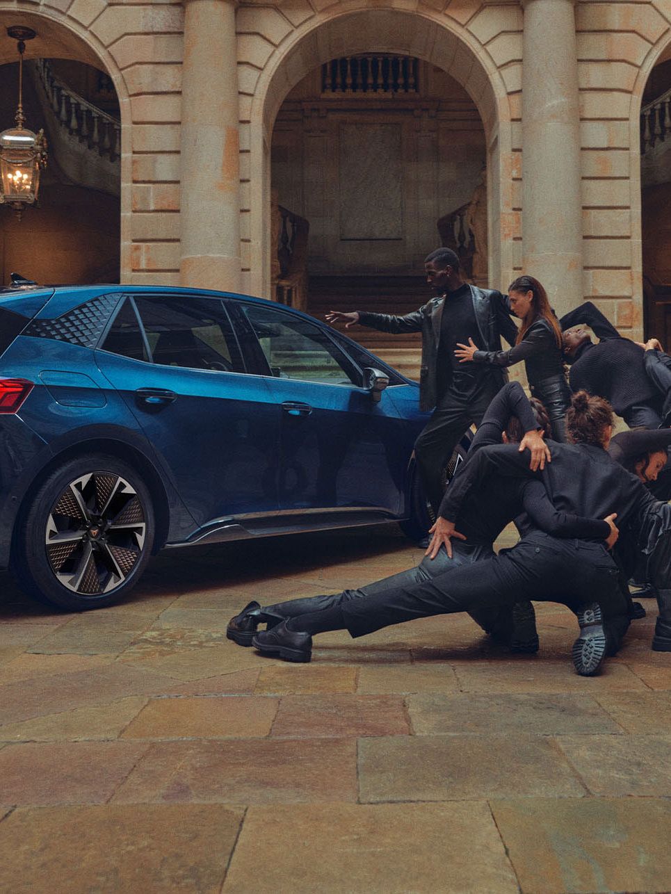 Eine Gruppe von Personen befindet sich neben einem blauen CUPRA Born.