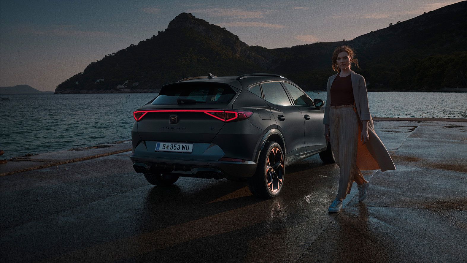 CUPRA Formentor Heckansicht. Eine Frau steht neben dem Fahrzeug.