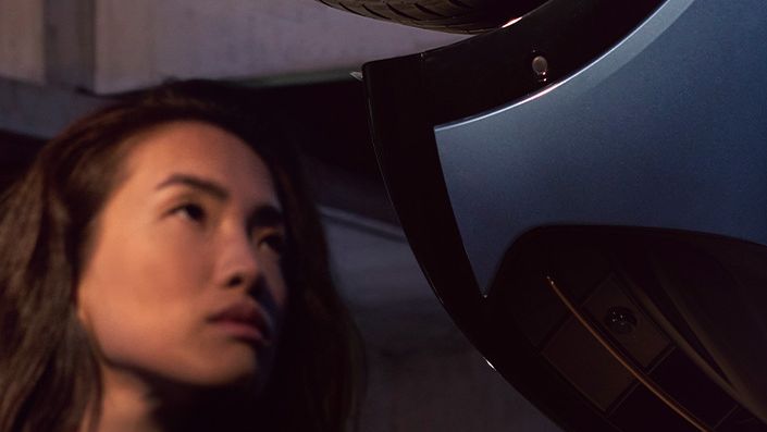 Detailansicht einer Felge des CUPRA Tavascan, eine Frau befindet sich neben dem Fahrzeug.