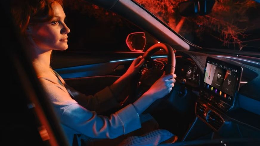 Eine Frau lenkt einen CUPRA und spricht mit dem CUPRA Connect Sprachassistent